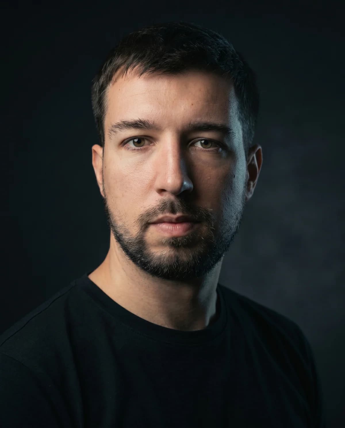 Portrait of Axel Jaworski, a dark studio headshot.